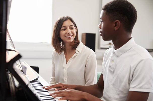 Male Pupil With Teacher Playing Piano In Music Lesson - Foto, Bild