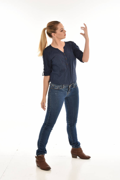 portrait pleine longueur de fille portant simple chemise bleue et jeans, debout pose.isolated sur fond de studio blanc
. - Photo, image