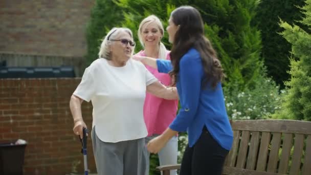 Young relative visiting senior lady in the garden at nursing home. - Footage, Video