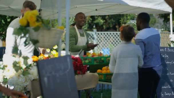 4k freundliche Standbesitzer verkaufen an Kunden auf einem Bauernmarkt - Filmmaterial, Video