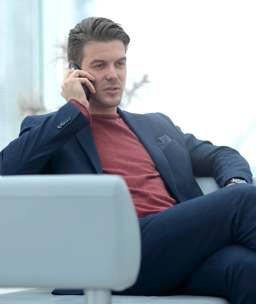 businessman talking on mobile phone sitting in a chair. - Zdjęcie, obraz