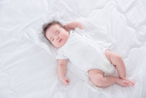 Säugling schläft morgens auf weißem Bett - Foto, Bild