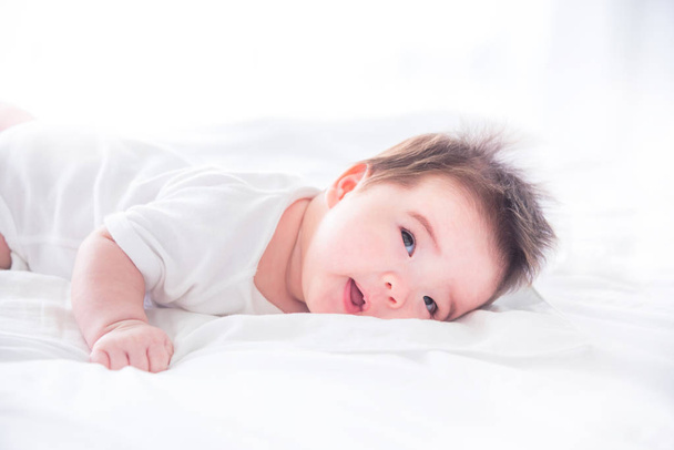 幼児の朝の白いベッドで目を覚ます - 写真・画像