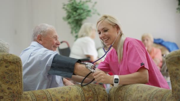 Молодая медсестра проверяет кровяное давление пожилых людей в доме престарелых
. - Кадры, видео
