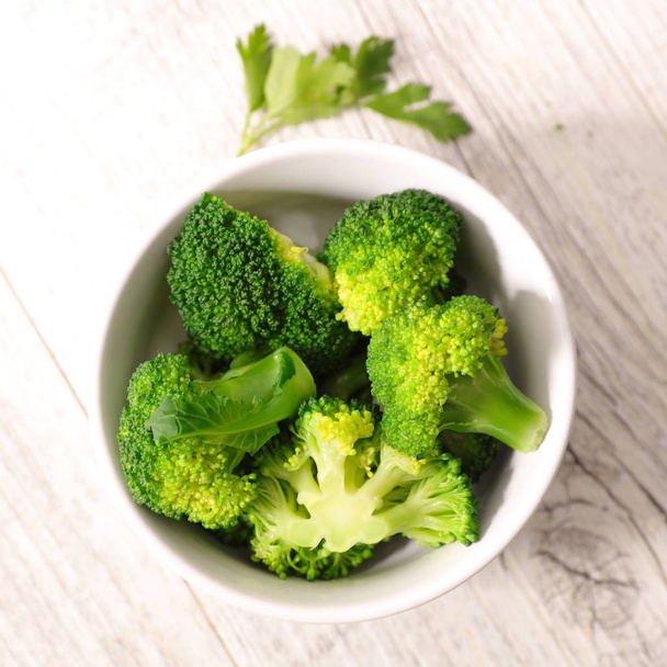 white bowl of broccoli on wooden table  - Фото, зображення