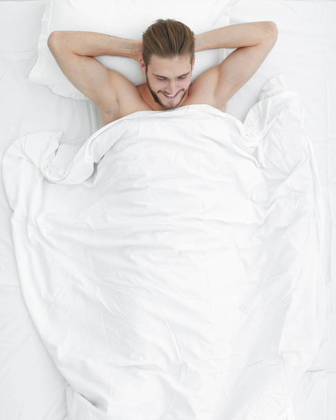 young man lying on a comfortable mattress. - Foto, Imagem