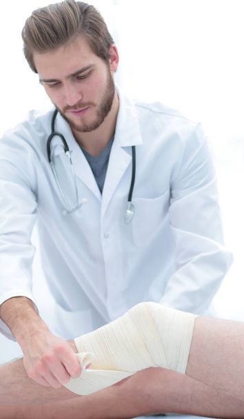 лікар дивиться пов'язку на ногу пацієнтів
 - Фото, зображення