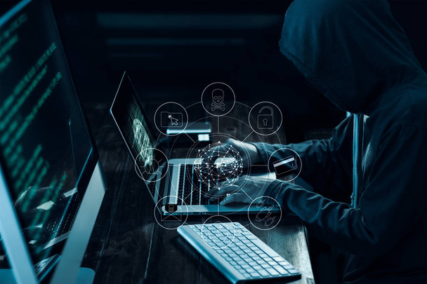 Hacker di computer con icone che lavorano e rubano informazioni su laptop in interfaccia scura. Concetto di criminalità informatica
 - Foto, immagini