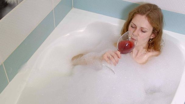 donna bionda bere vino mentre fa il bagno
. - Foto, immagini