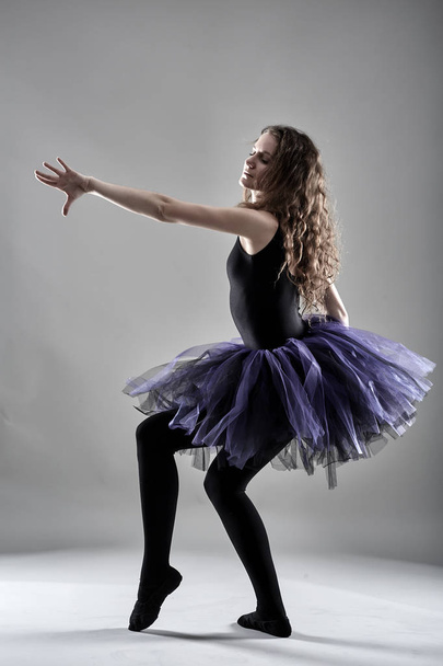 Young female dancer in posing against gray background - Foto, Imagen