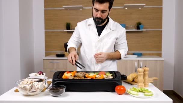 Koch in der Küche grillt Fleisch und Gemüse - Filmmaterial, Video