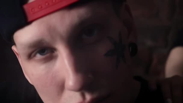 Giovane ragazzo figo in snapback con tatuaggi viso davanti al muro di mattoni con le ragazze
 - Filmati, video