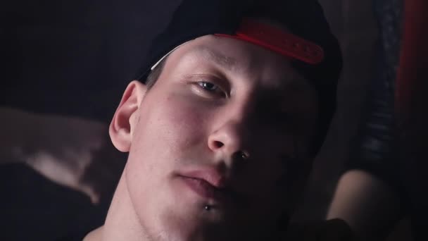 Fiatal rapper férfi sapka arc-tetoválás előtt téglafal, lányok - Felvétel, videó