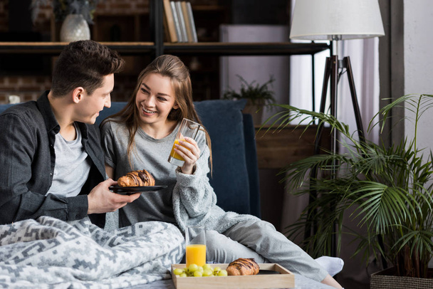 couple having breakfast in bed in morning - Foto, afbeelding