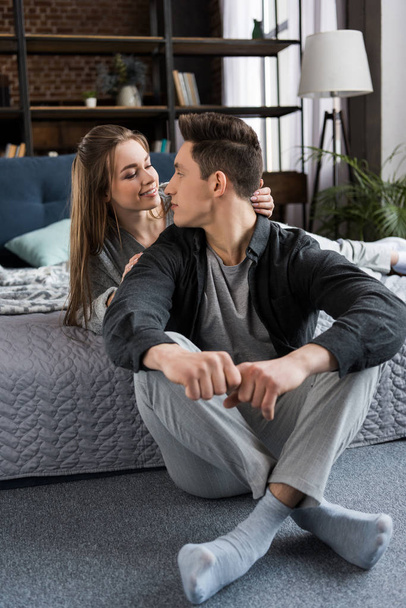 affectionate couple looking at each other in bedroom - Photo, image