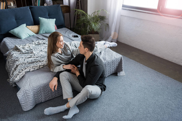 attractive couple looking at each other in bedroom - Valokuva, kuva