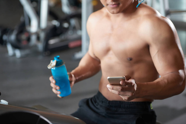 Imagen de primer plano del deportista usando un smartphone en el gimnasio
 - Foto, imagen