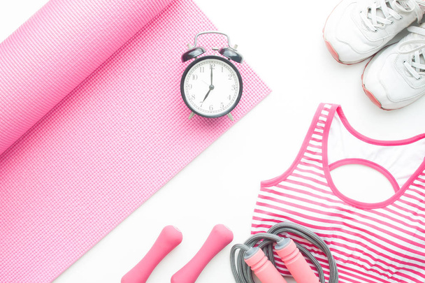 Vista superior de artículos de yoga fitness y reloj despertador sobre fondo blanco, concepto de estilo de vida saludable
 - Foto, imagen