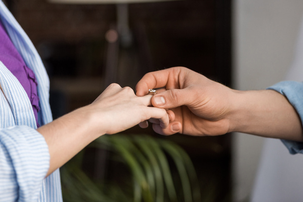 cropped image of boyfriend proposing girlfriend and wearing engagement ring - Foto, Imagem