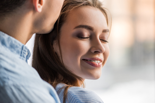 cropped image of boyfriend kissing happy girlfriend - Valokuva, kuva