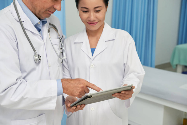 Dois médicos discutindo diagnóstico em tablet digital
 - Foto, Imagem
