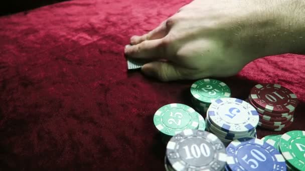 game of poker. the combination of a pair of aces. a chance to win. man makes a bet. lie around the chips. the game is on a red cloth velour table. - Filmmaterial, Video