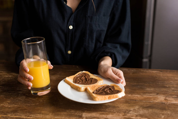 cropped image of girl holding plate with toasts with hearts from chocolate paste, valentines day concept - Photo, Image