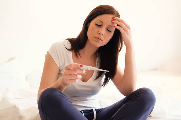 女性が落ち込んでいる、悲しい気持ちで妊娠検査を見た後 - 写真・画像