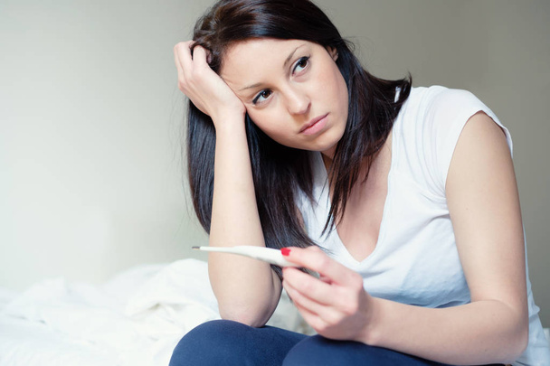 Woman feeling depressed and sad after looking at pregnancy test - Foto, imagen