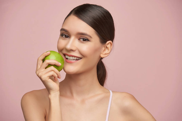 Счастливая молодая женщина ест свежее зеленое яблоко
 - Фото, изображение