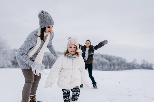 Mother have active time with daughters in winter park - Photo, Image