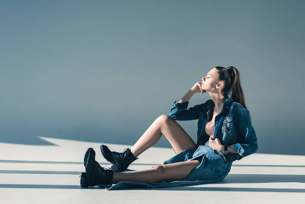 attractive woman in denim clothes sitting on floor - Zdjęcie, obraz