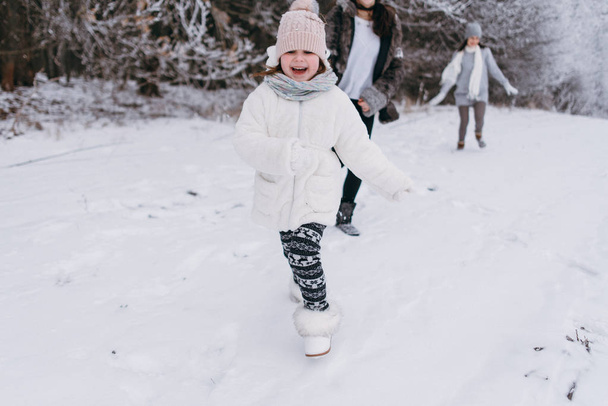 Mutter mit Töchtern läuft durch verschneiten Pfad - Foto, Bild
