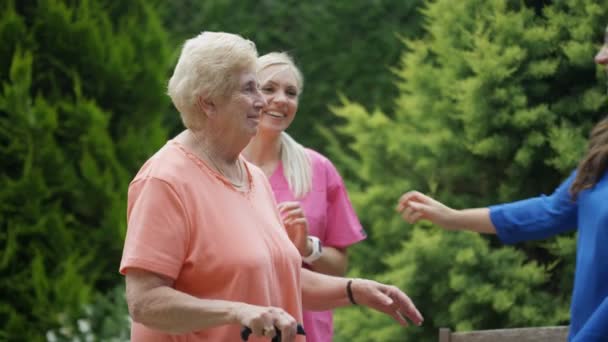 Junge Verwandte besuchen Seniorin im Garten des Pflegeheims. - Filmmaterial, Video