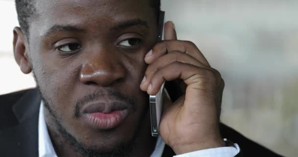 Africký podnikatel mluví o chytrý telefon v café detailní - Záběry, video