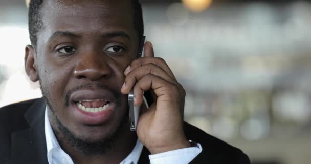 Africký podnikatel mluví o chytrý telefon v café detailní - Záběry, video