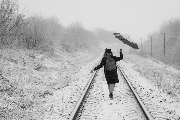 Милая молодая девушка держит зонтик в руках зимнего сезона
 - Фото, изображение