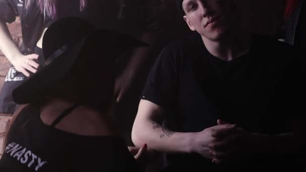 Nuori rikollinen mies snapback tatuoinnit edessä tiiliseinä tyttöjen kanssa
 - Materiaali, video