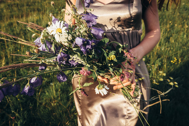 Bouquet of fresh flowers collected in the mountains in the hands - Photo, Image