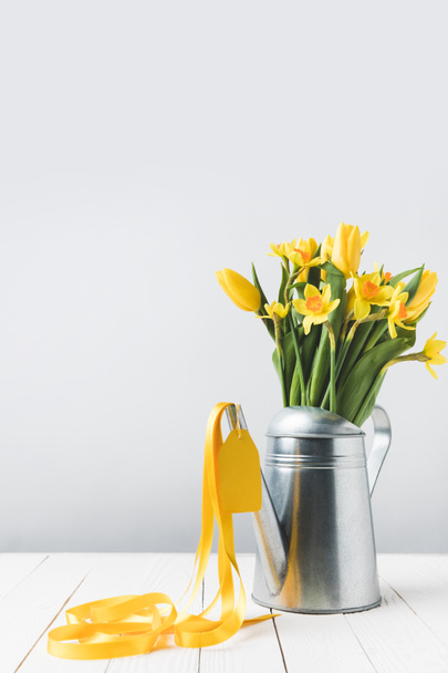gyönyörű sárga tavaszi virágok a locsolás is a szürke - Fotó, kép