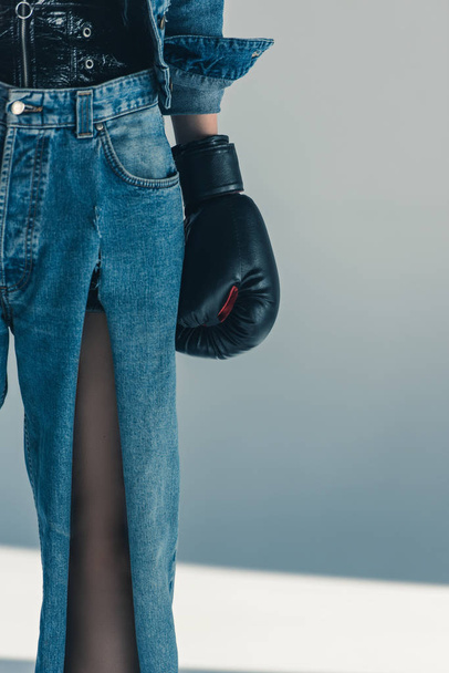 cropped view of girl in jeans and boxing glove  - Фото, зображення