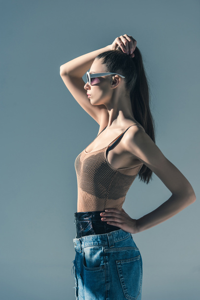 beautiful girl posing in sunglasses with ponytail hairstyle, isolated on grey - Fotografie, Obrázek