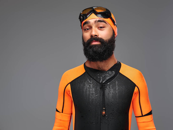 Портрет бородатого мужчины в оранжевом неопреновом водолазном костюме и маске для погружений на сером фоне
. - Фото, изображение