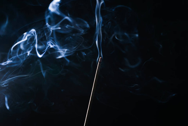 on a black background smoking incense stick - Photo, Image