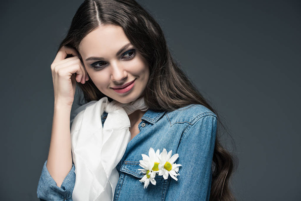 χαμογελαστό κορίτσι που παρουσιάζουν σε κασκόλ και βαμβακερό πουκάμισο με λουλούδια, απομονώνονται σε γκρι - Φωτογραφία, εικόνα