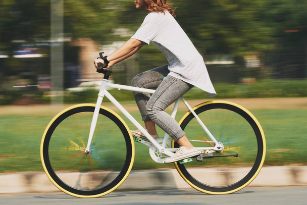 Oříznutý obraz cyklistické mladé ženy, rozmazaného pohybu - Fotografie, Obrázek