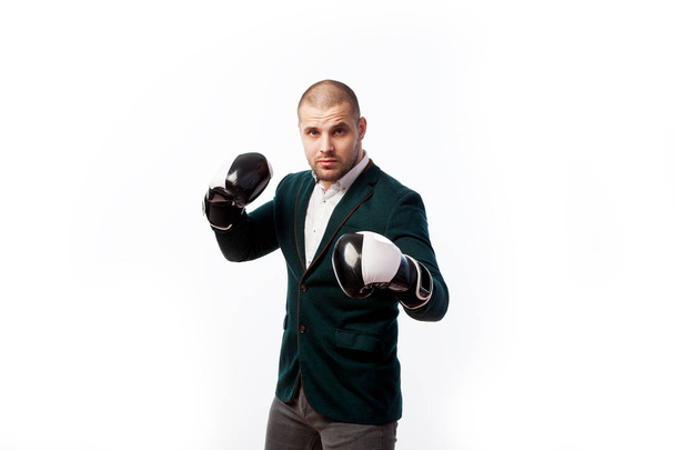 若いハゲ男が、白いシャツ、緑のスーツと白でポーズ ボクシング グローブで自信を持ってマネージャー孤立の背景 - 写真・画像