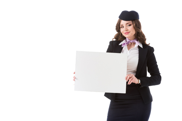 beautiful stewardess holding empty board and looking at camera isolated on white - Photo, Image