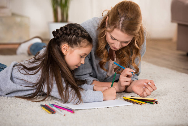 mãe e filha desenho com lápis coloridos em casa
 - Foto, Imagem