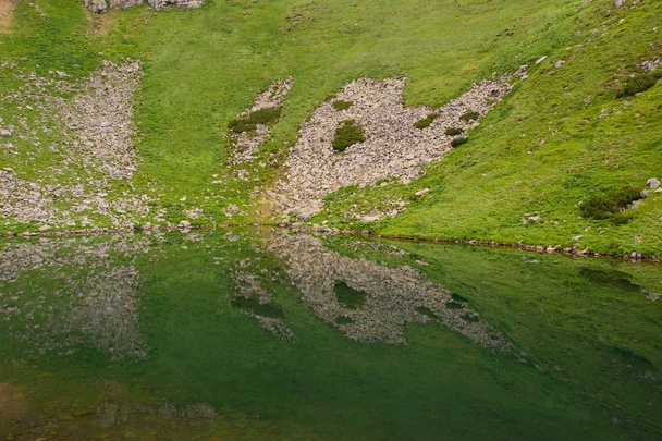 Uma borboleta abstrata! Incrível tiro da colina rochosa e é reflexo no lago da montanha, fazendo uma bela forma de borboleta
. - Foto, Imagem
